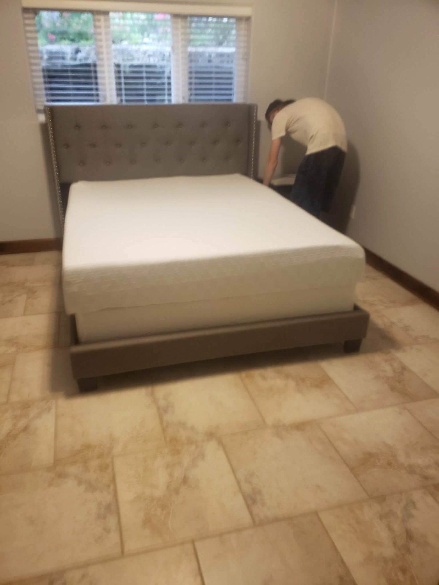 Upholstered tufted queen bed being assembled