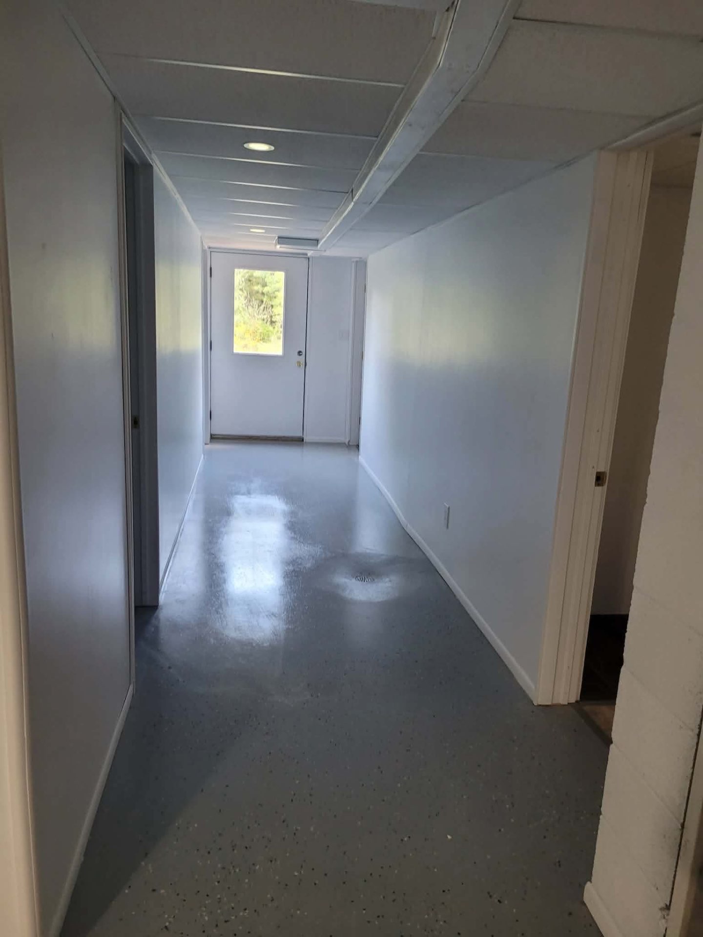 Basement hallway with fresh paint and glossy epoxy floor